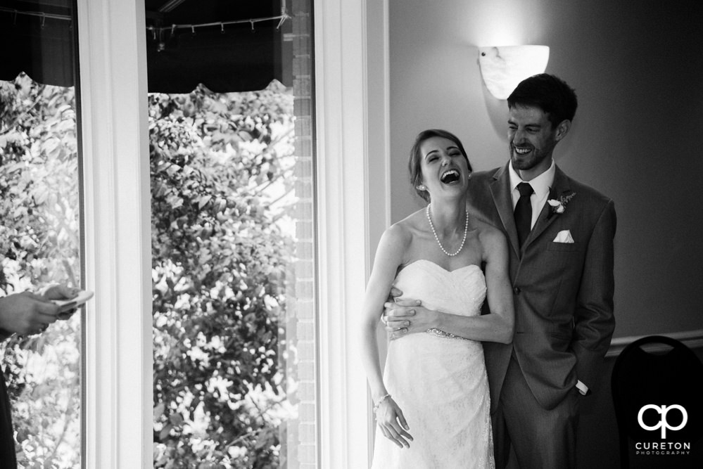 Bride and groom watching as the wedding party gives them a toast.