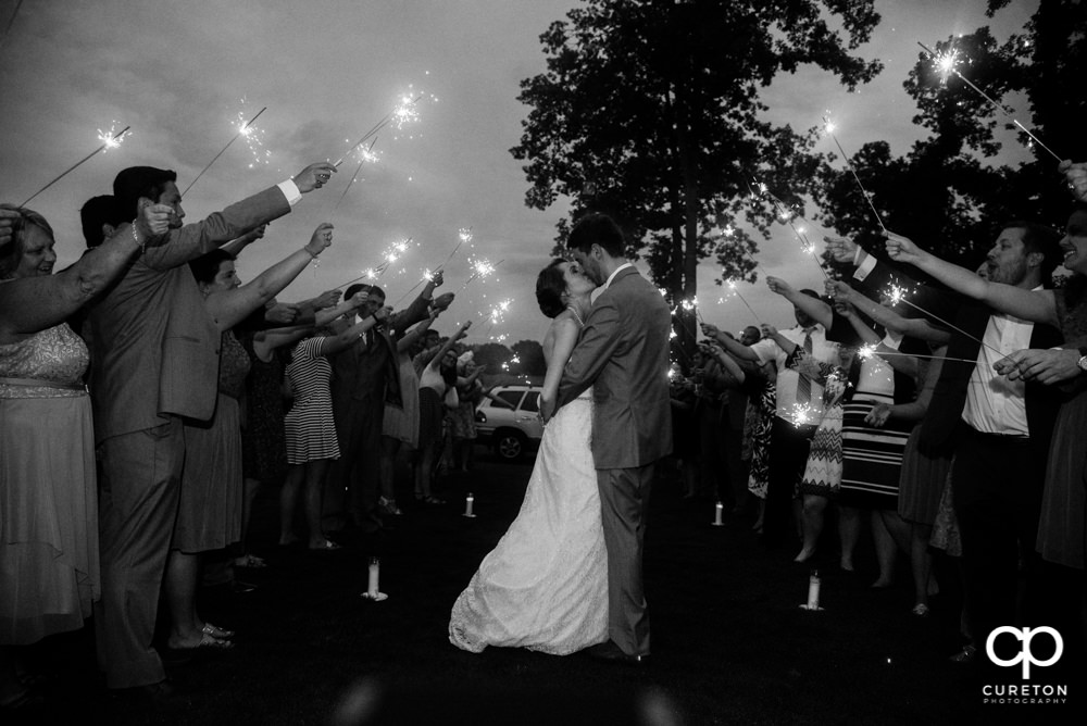 Bride and groom making a grand exit though sparklers after their Holly Tree wedding reception.