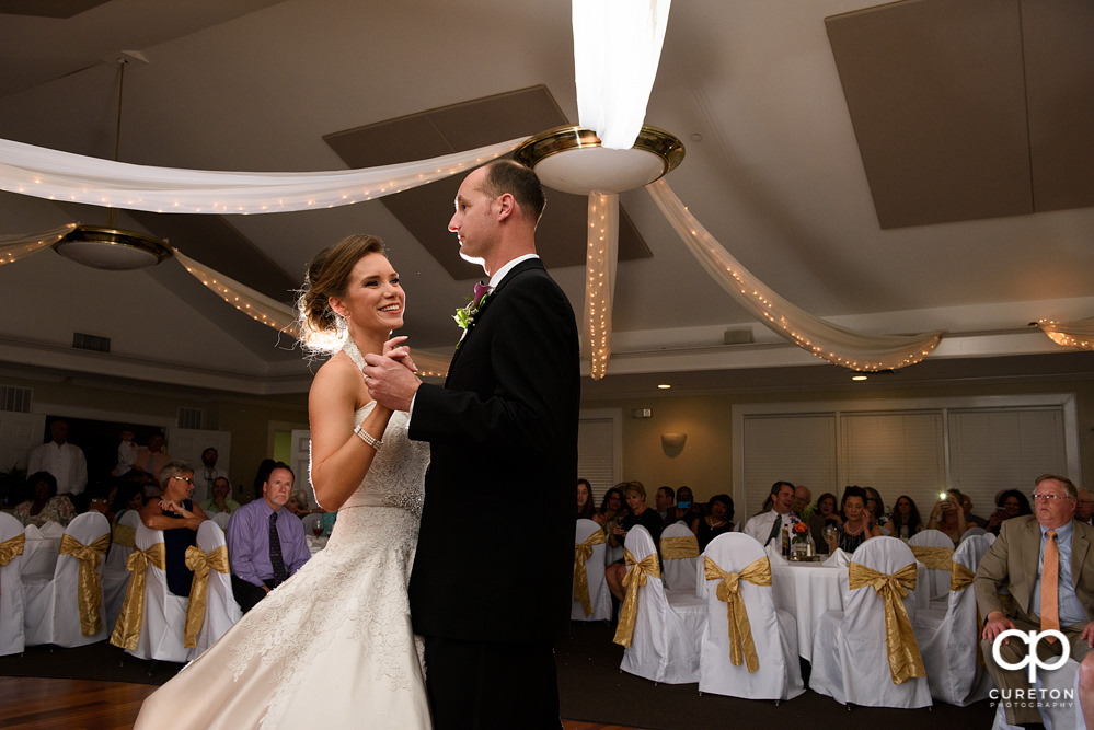 Bride and groom having a first dance at the wedding reception at Holly Tree Country Club.