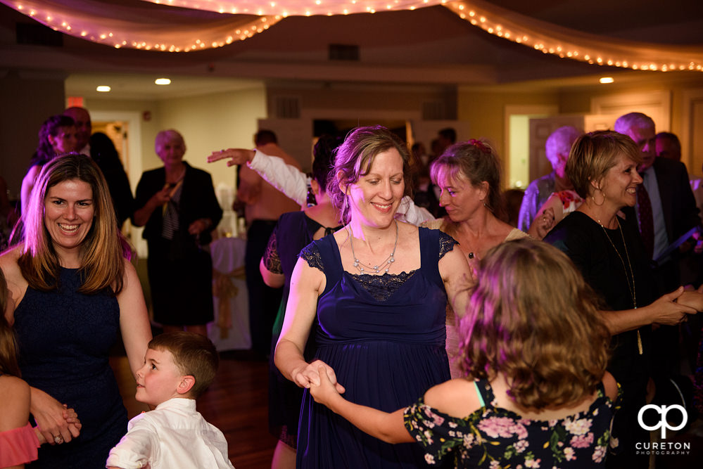 Wedding guests dancing at a Holly Tree Country Club wedding reception while Uptown Entertainment dj's.
