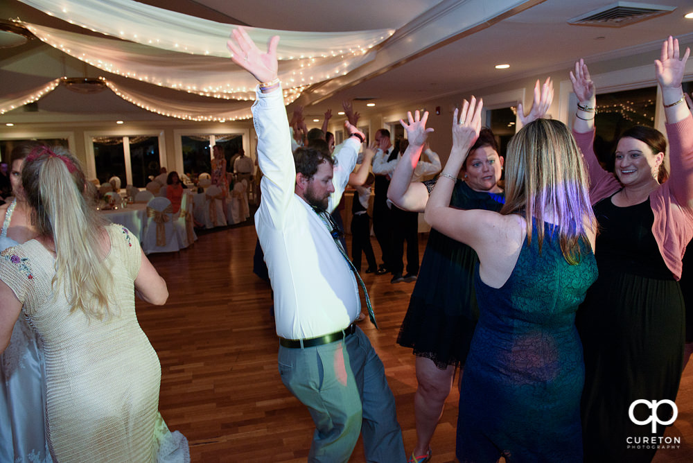 Wedding guests dancing at a Holly Tree Country Club wedding reception .