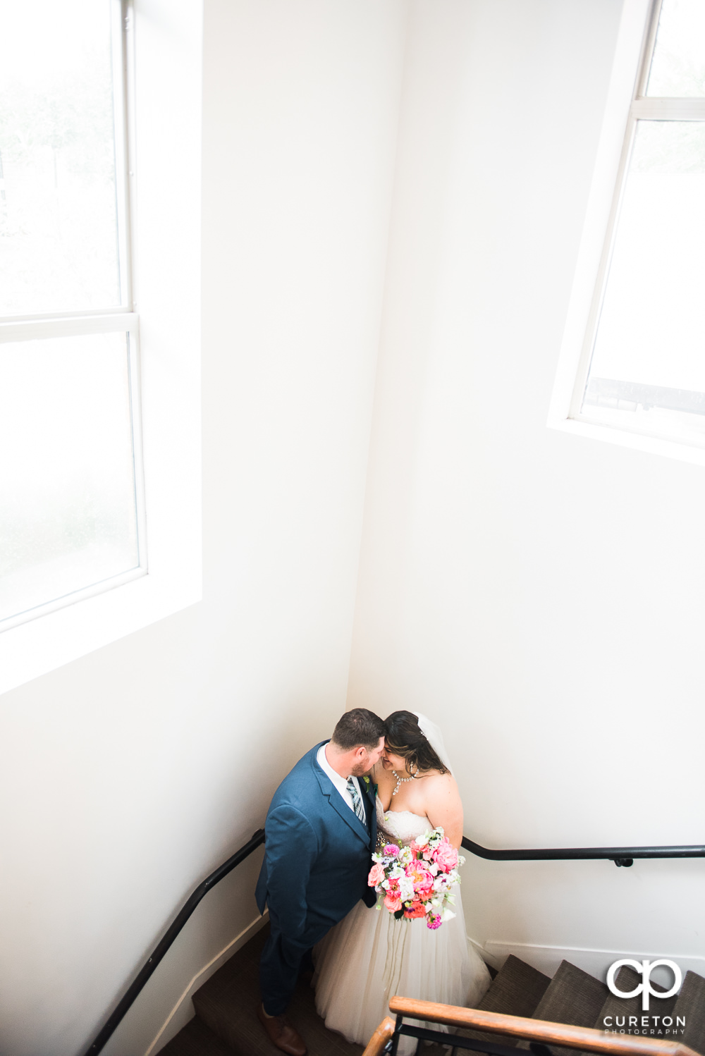 Bride and groom on stairs after their Huguenot Loft wedding in Greenville,SC.