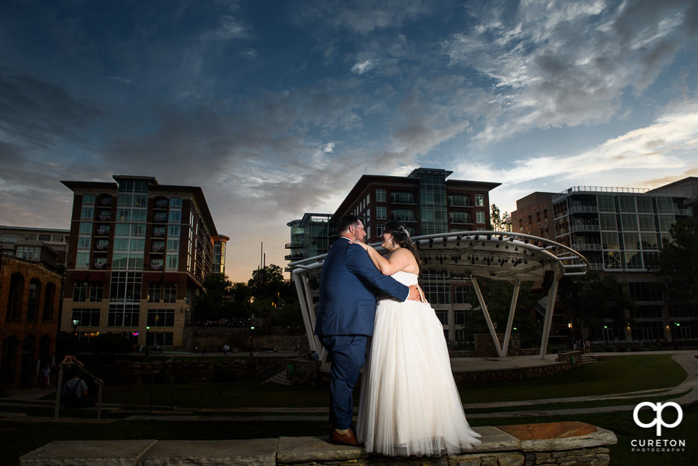 Bride and groom dancing at sunset with the backdrop of downtown Greenville.
