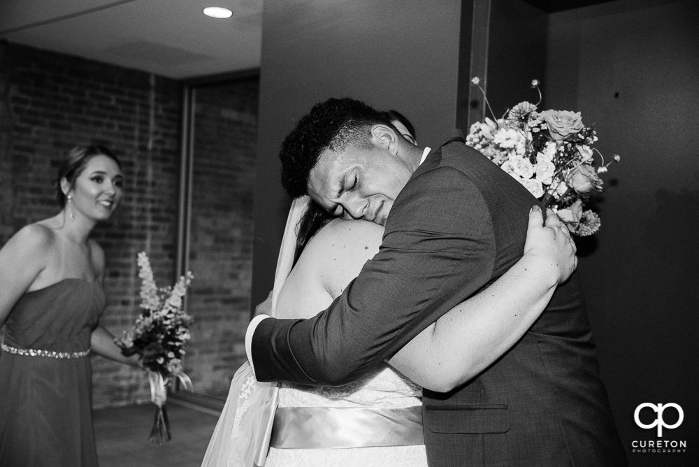 Bride's brother hugging his sister.