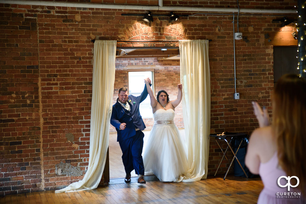 Bride and groom making an entrance into the reception.