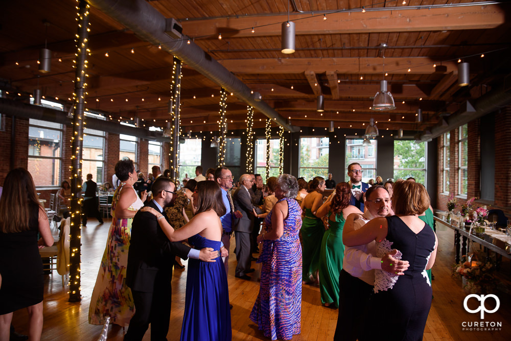 Guests dancing at the Huguenot Loft wedding reception in Greenville SC.