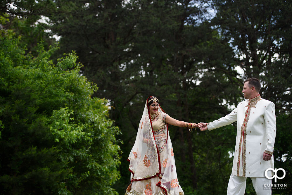Bride leading groom after their Indian wedding at Embassy Suites in Greenville,SC.