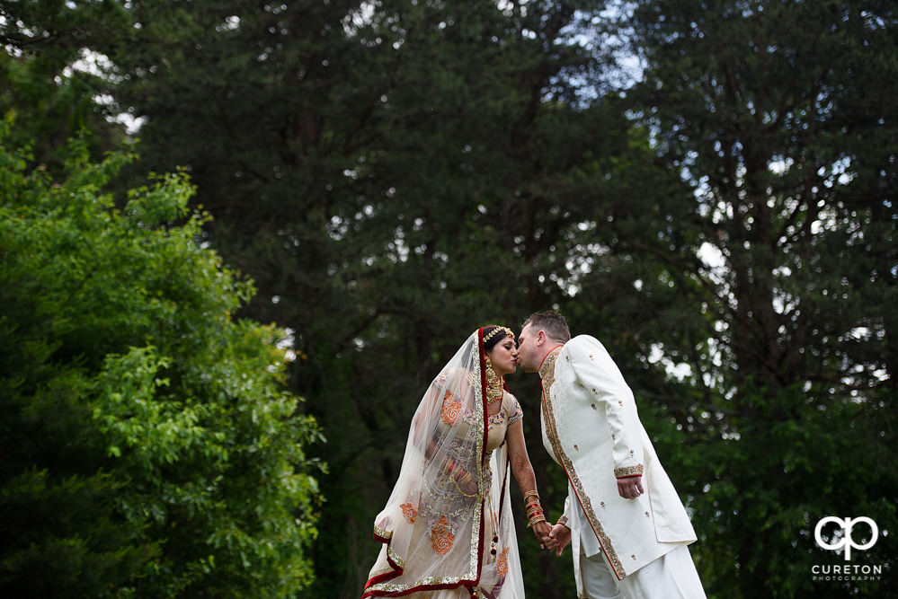 Groom kissing his bride after their Indian wedding at Embassy Suites in Greenville,SC.