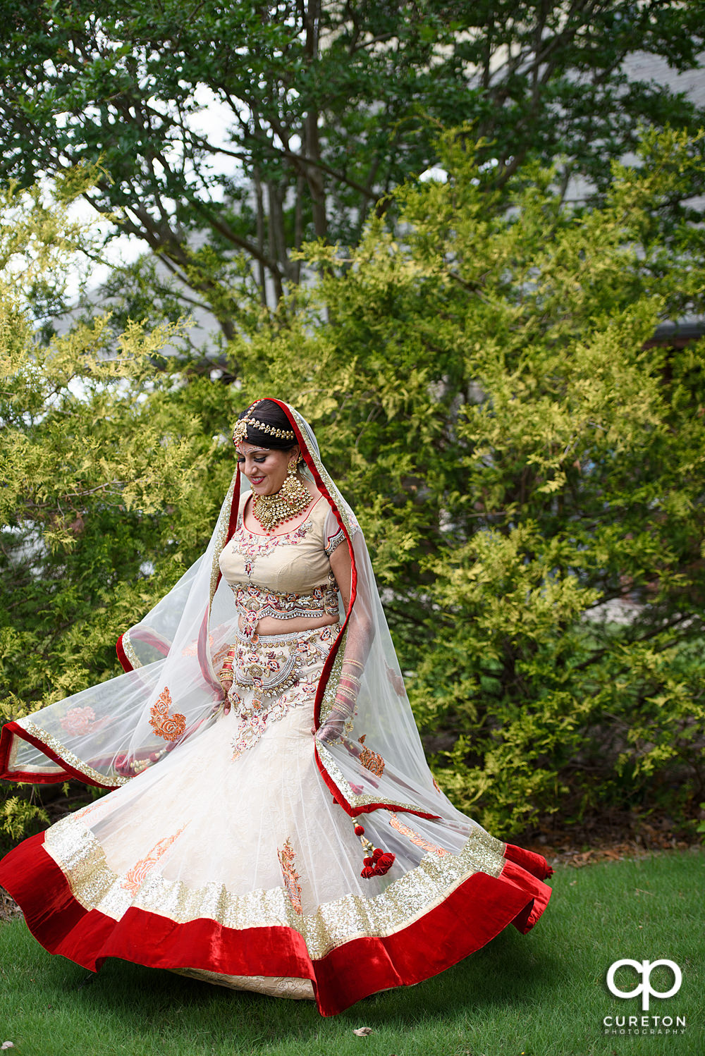 Indian bride twirling in her dress.