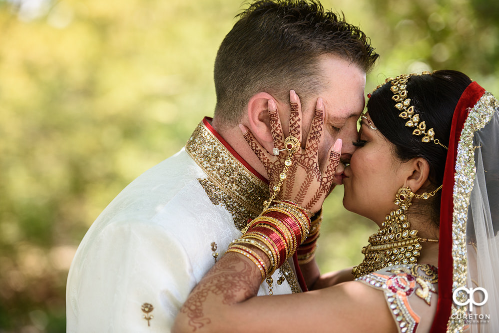 Bride kissing her groom after the ceremony at their Indian wedding at Embassy Suites in Greenville,SC.