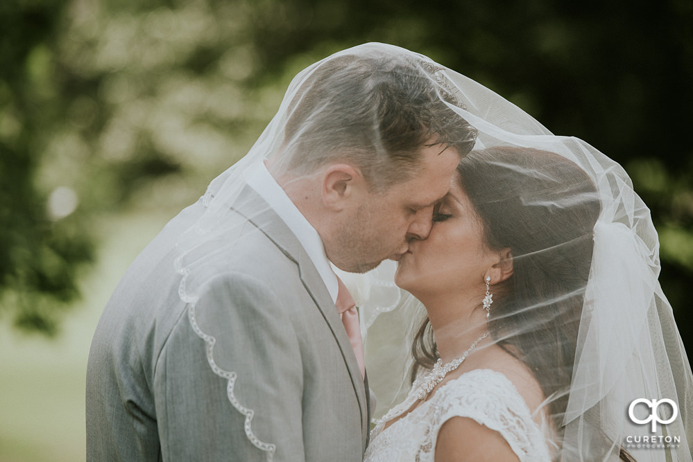 Bride and groom under the veil.