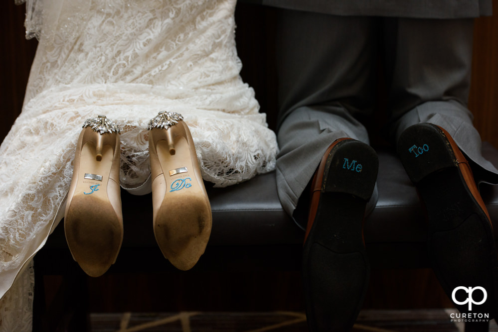 Bride and groom's shoes with words on them.