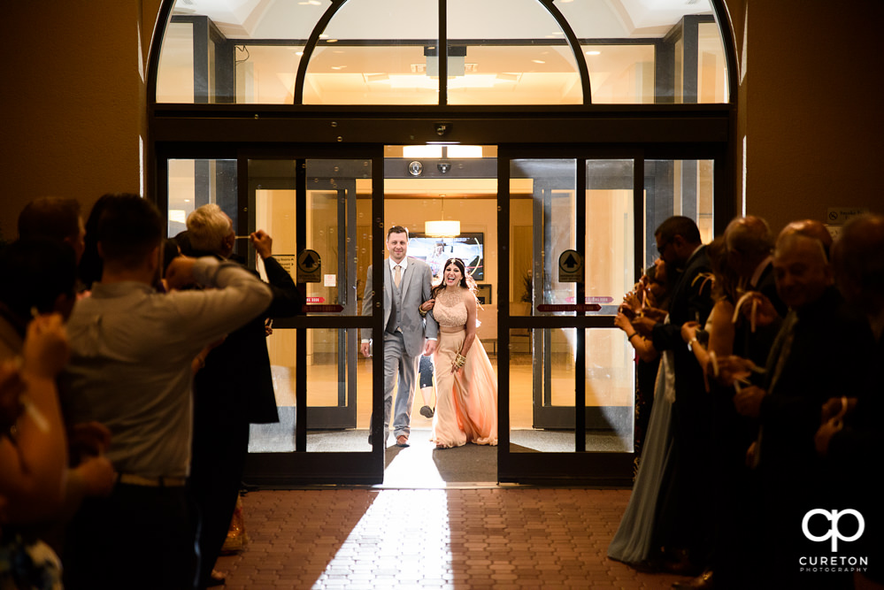 Bride and groom grand exit though bubbles at Embassy Suites.