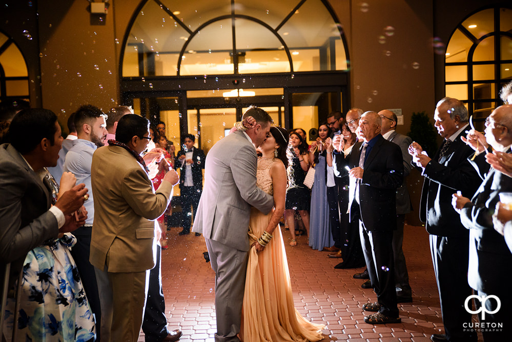 Bride and groom grand exit though bubbles at Embassy Suites.