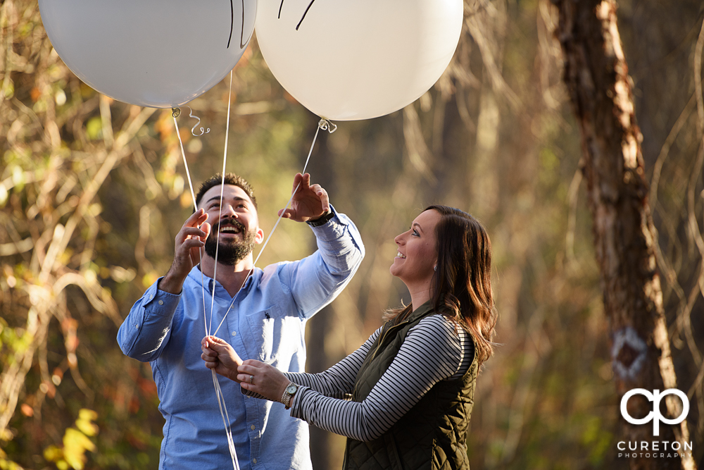 Engaged couple with balloons.