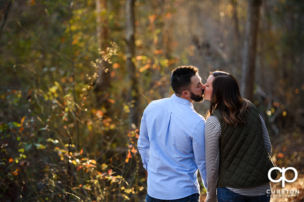 Future bride and groom stopping along the trail for a quick kiss.