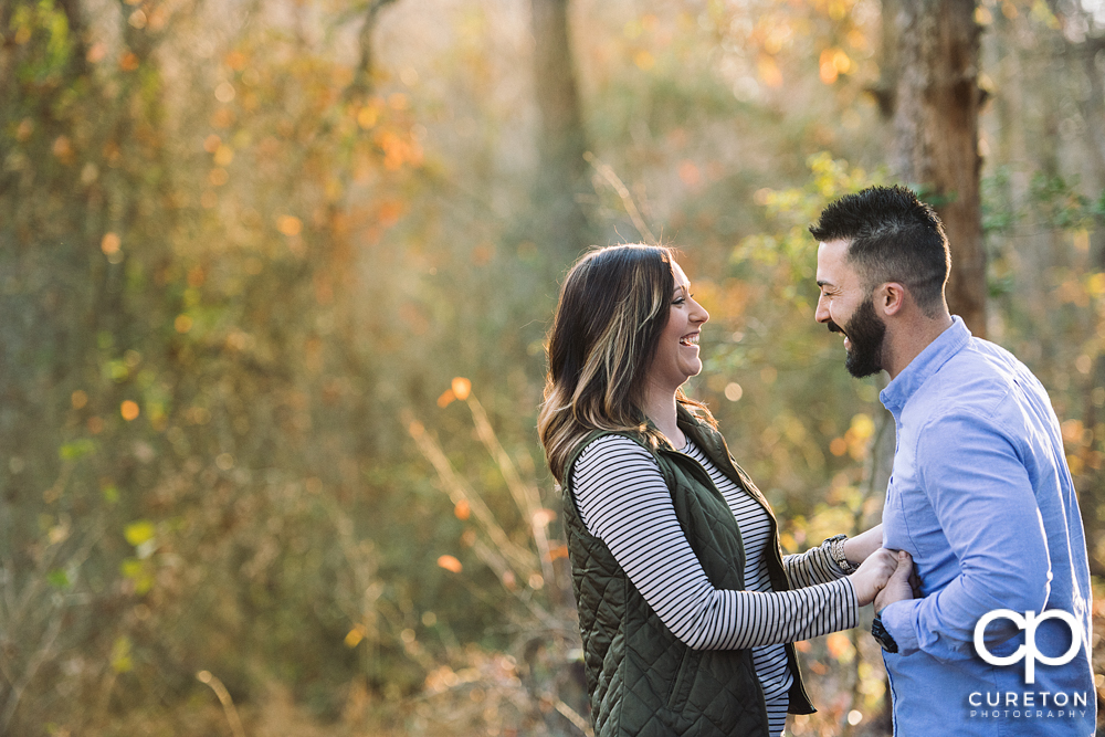 Engaged couple laughing.