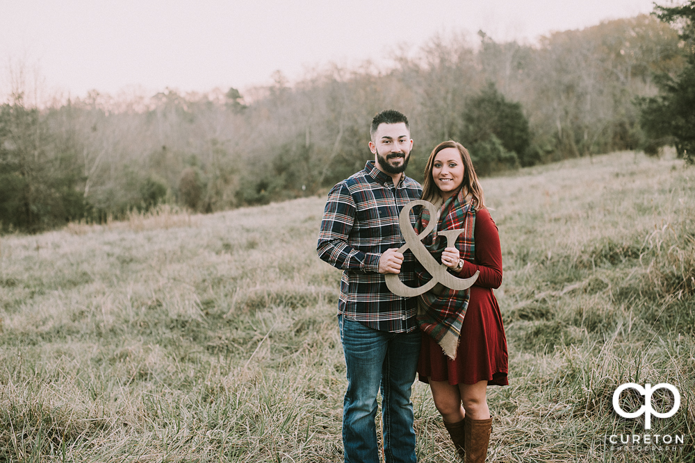 Bride and groom holding an and symbol.