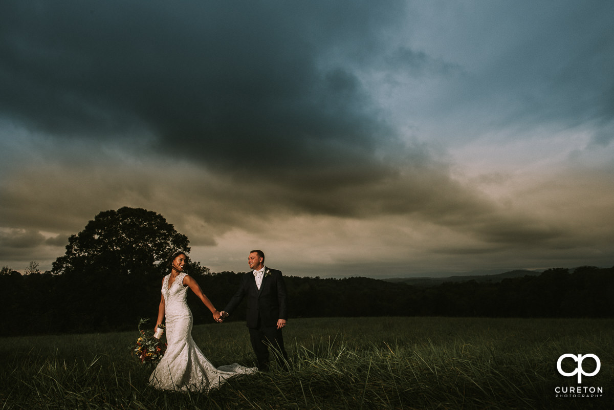 Bride and groom walking in the field at Lindsey Plantation.