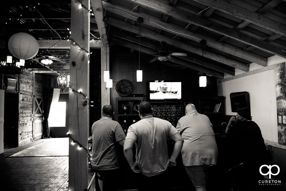 Groomsmen watching football before the wedding.