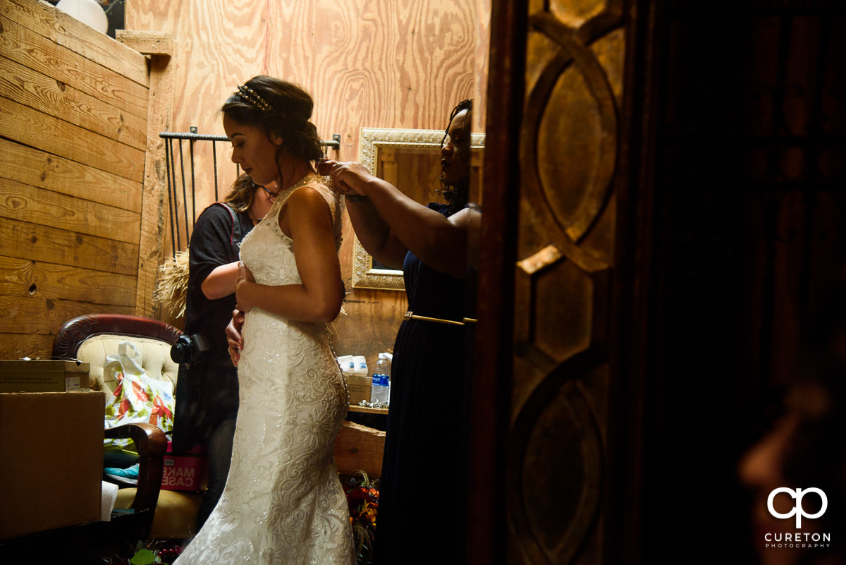 Bride putting on her dress at Lindsey Plantation.