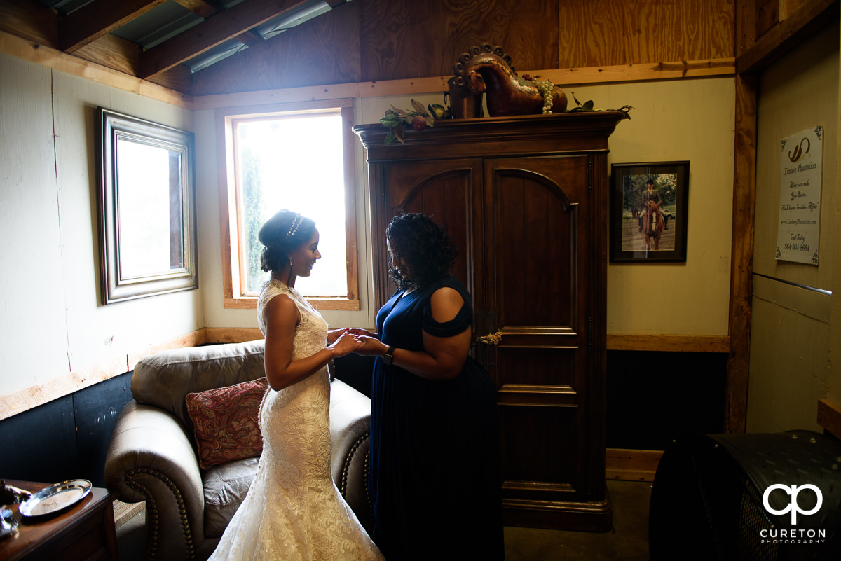 Bride and her mother in front of a window.