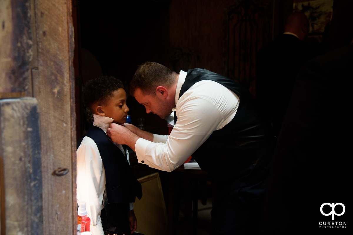 Groom fixing his son's tie.