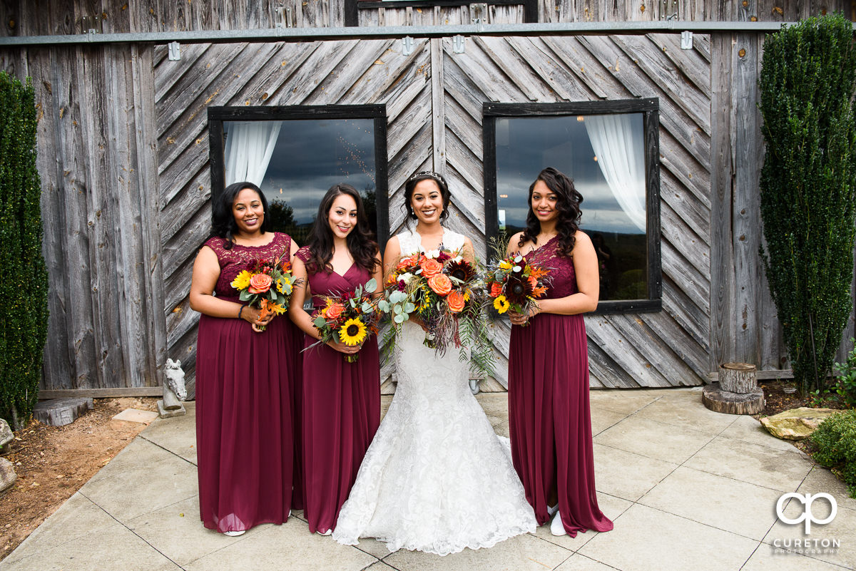 Bride and bridesmaids in front of the barn at Lindsey Plantation in Taylors,SC.