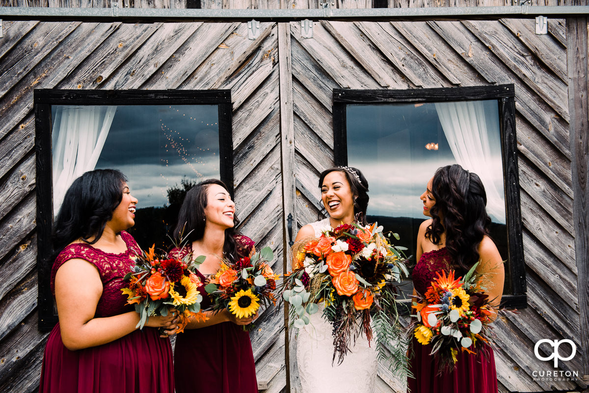 Bride laughing with her bridesmaids before the wedding.
