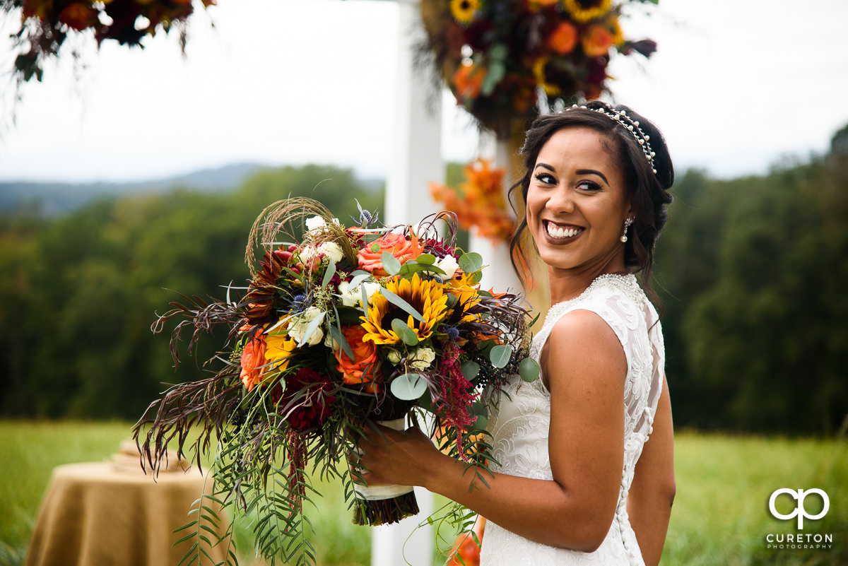 Bride smiling with her fall florals.