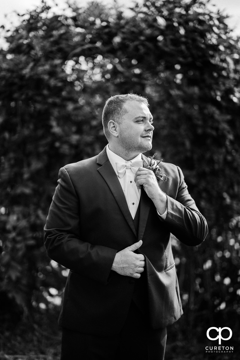 Groom adjusting his tie.