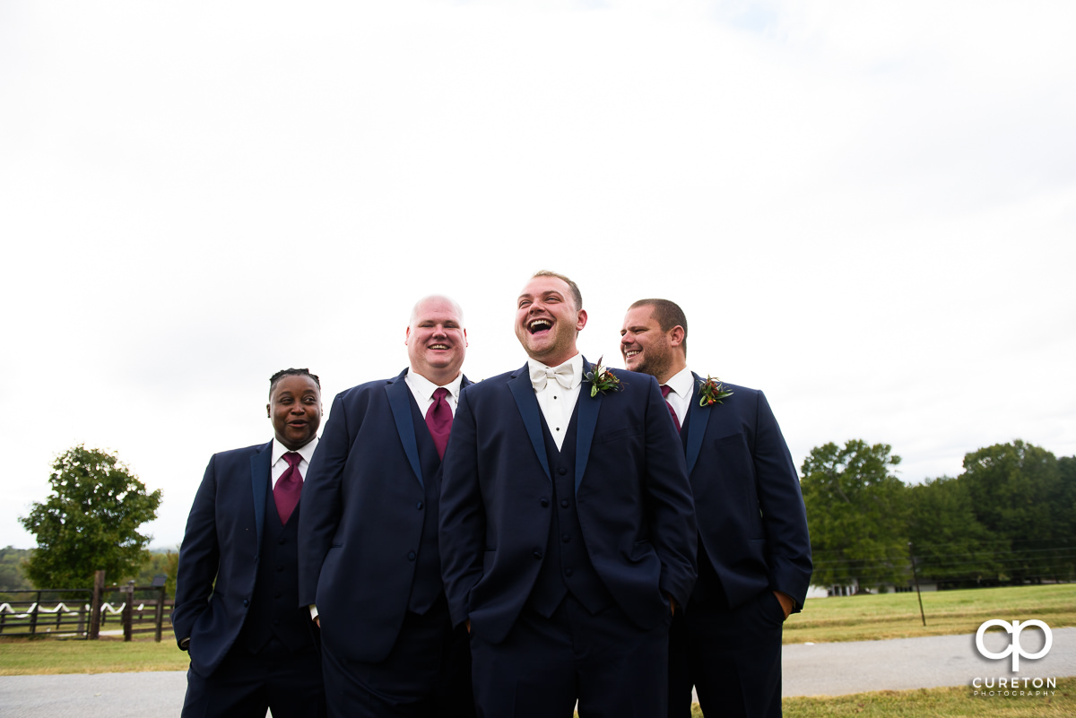 Groom laughing with groomsmen.