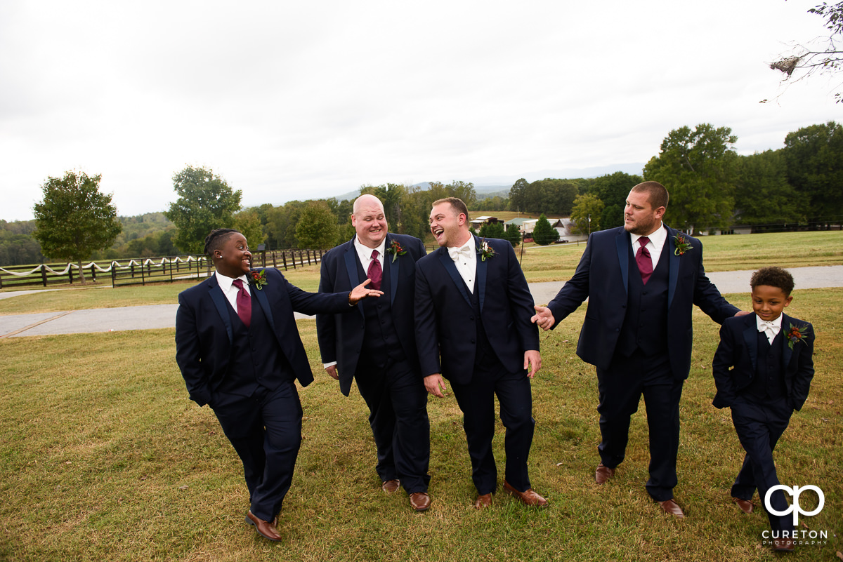 Groomsmen walking in the field.