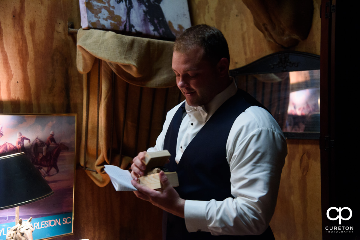 Groom opening his gift from the bride.