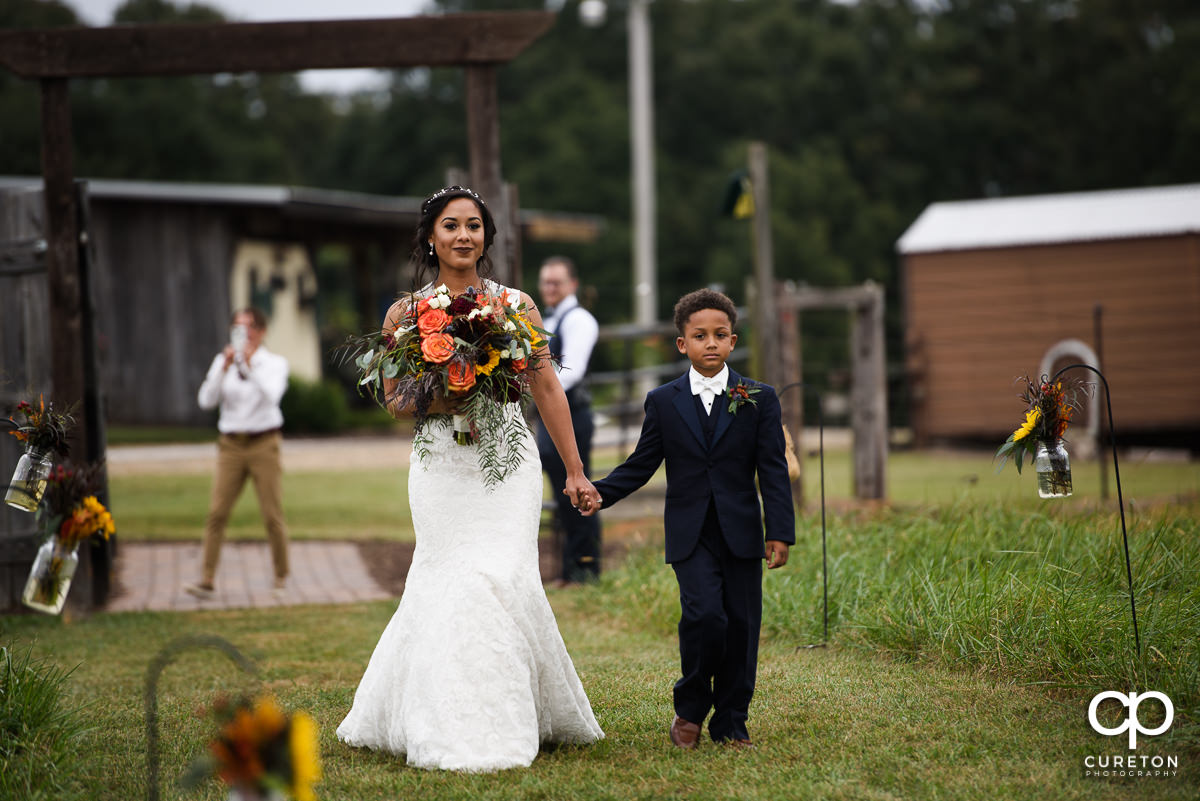 Bride and her son walk down the aisle at her wedding at at Lindsey Plantation in Taylors,SC.
