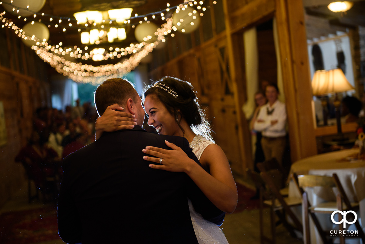Bride smiling during her first dance with her husband.