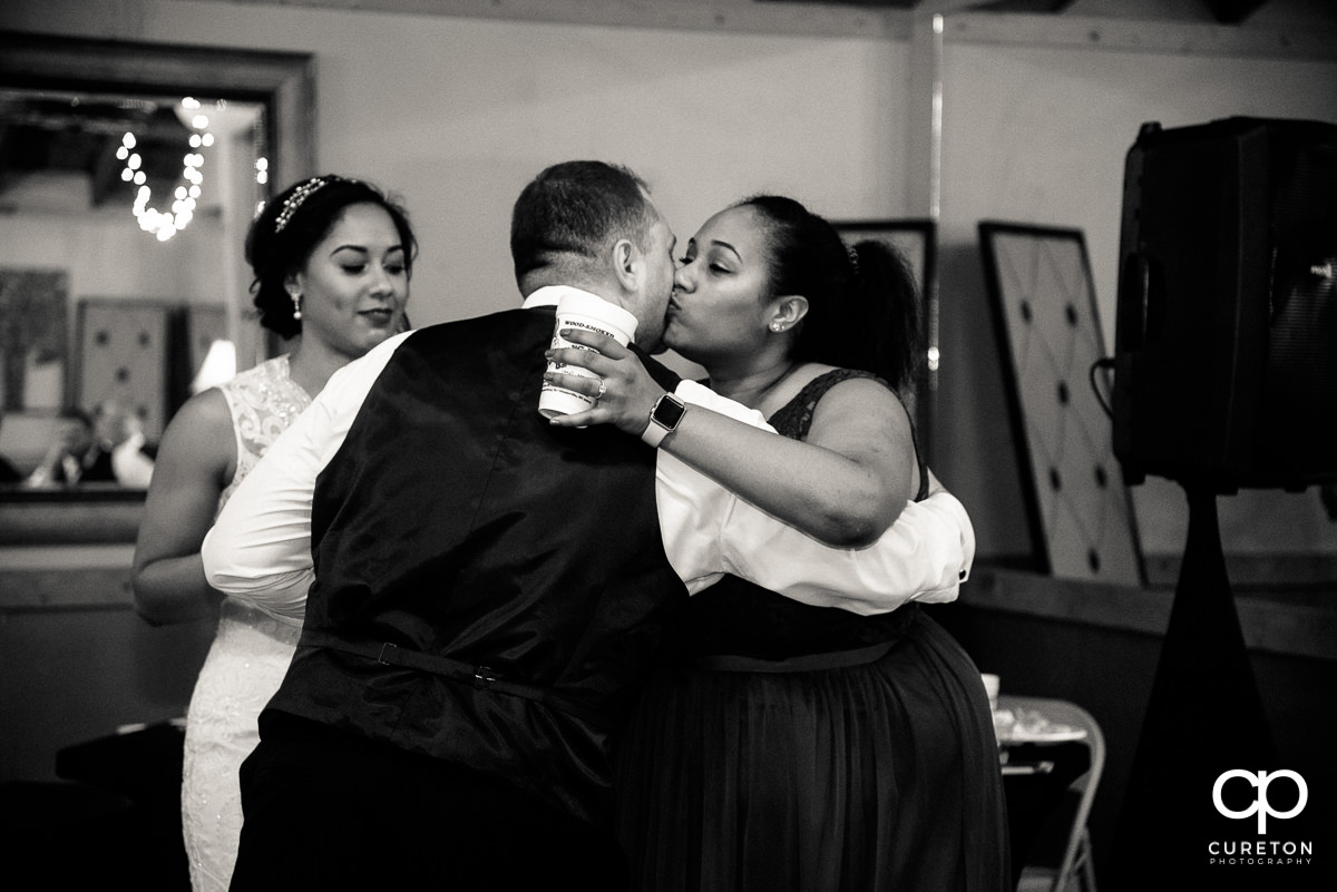 Bridesmaids hugging the groom.