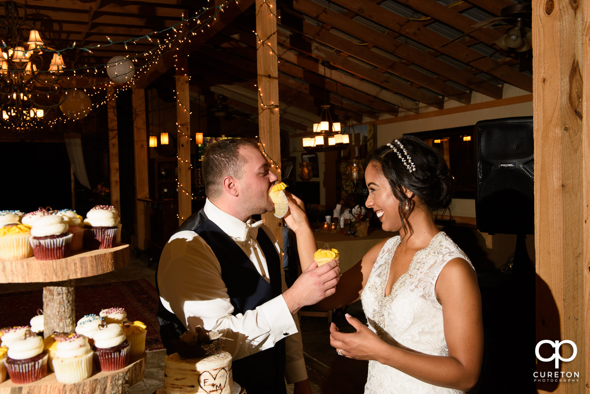 Bride feeding the groom cake.