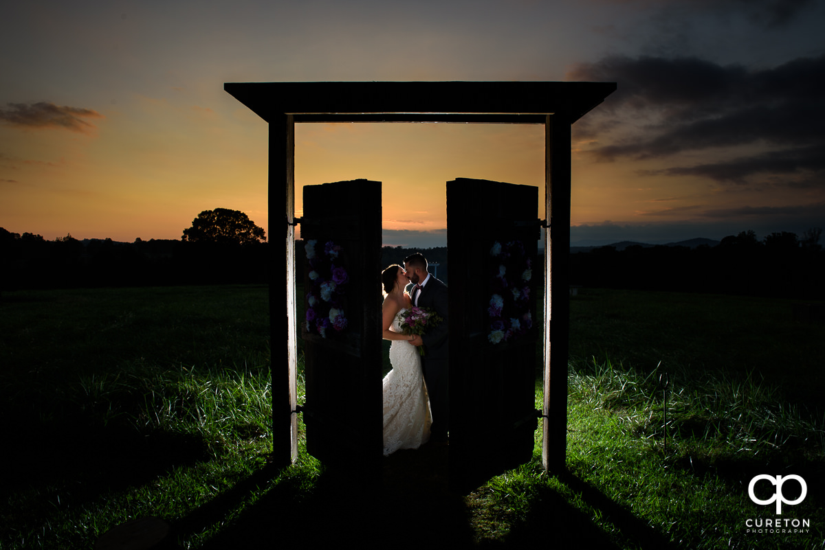 Bride and groom kissing at sunset in the field at Lindsey Plantation.