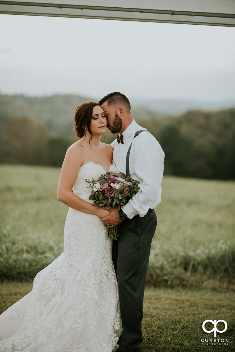 Bride and groom in the field at their rustic wedding minutes from Greenville,SC.