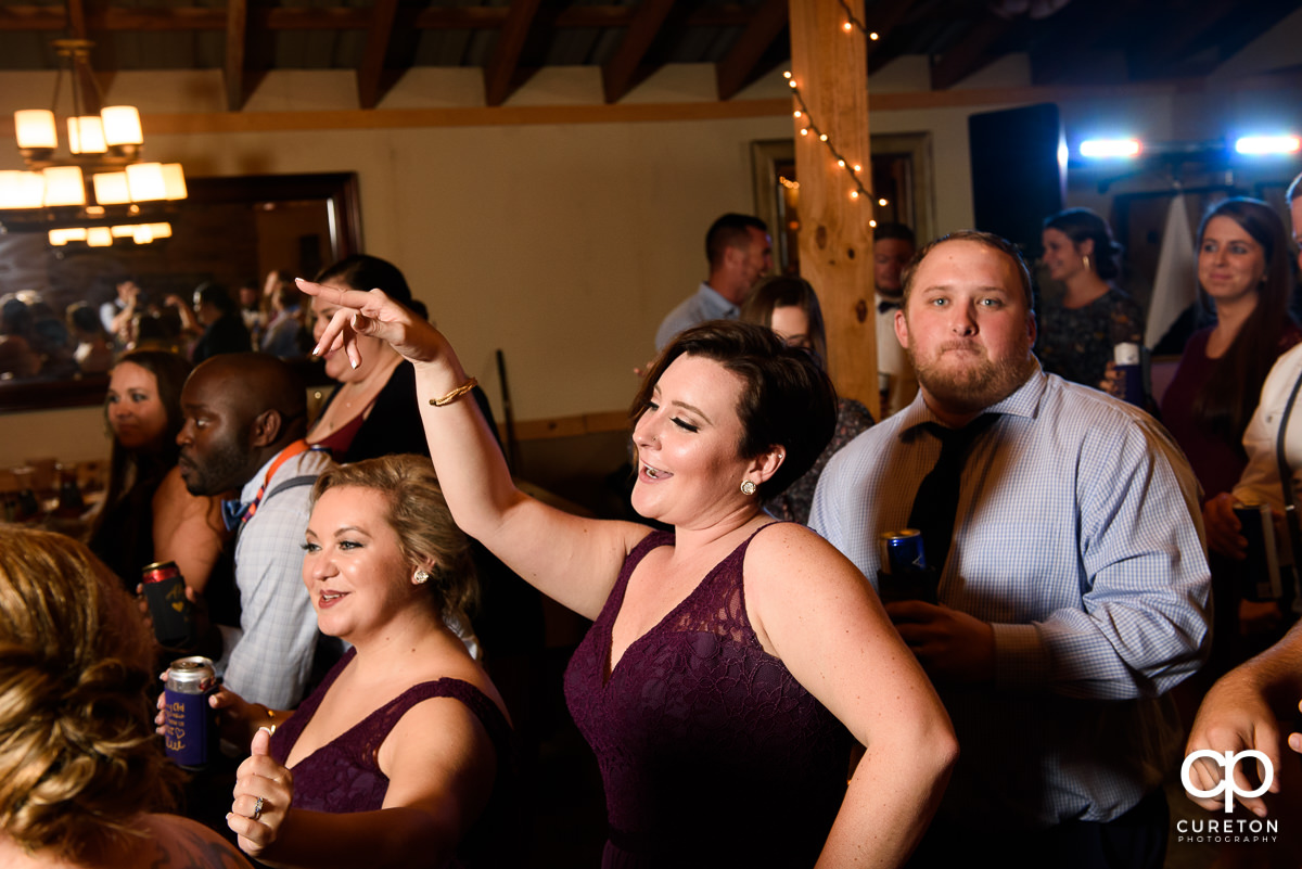Bridesmaid dancing on a packed dance floor.