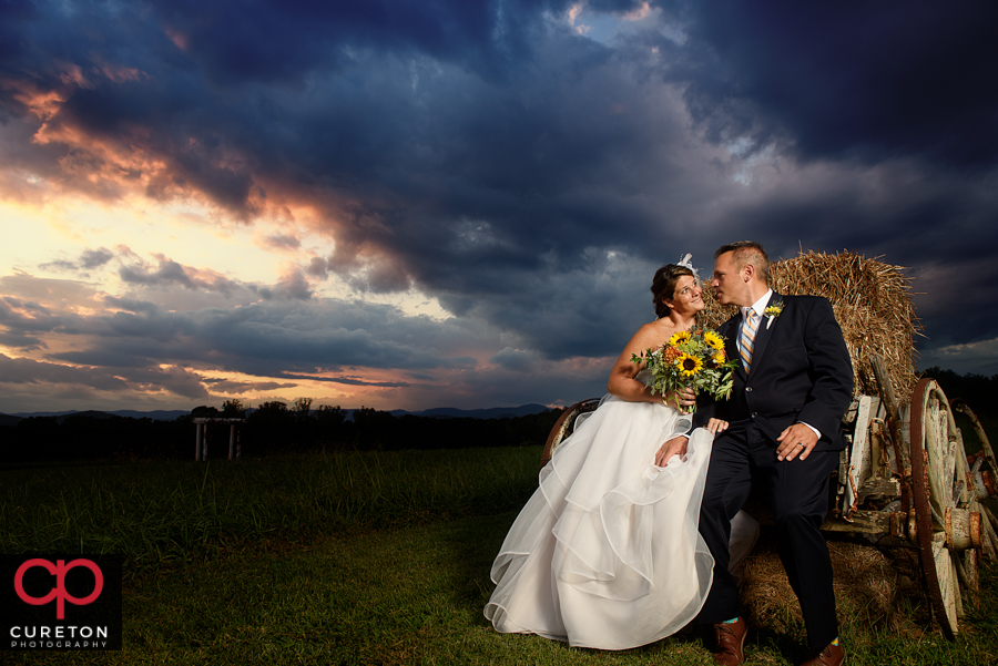 Bride and Groom on a haybale.