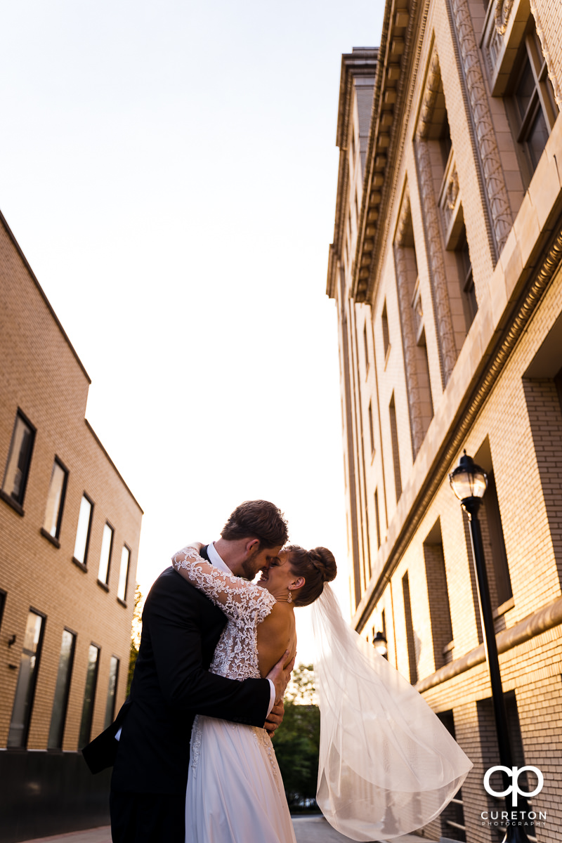Groom dipping his bride while dancing in the streets of downtown Greenville,SC after their wedding.