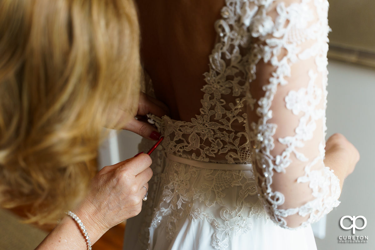 Bride's mom helping her in to her dress before the ceremony.