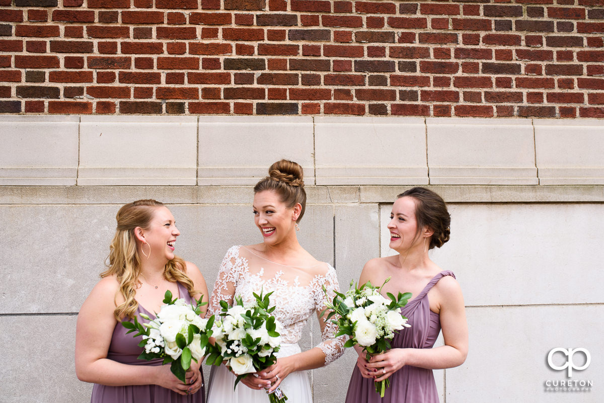 Bride laughing with her bridesmaids.