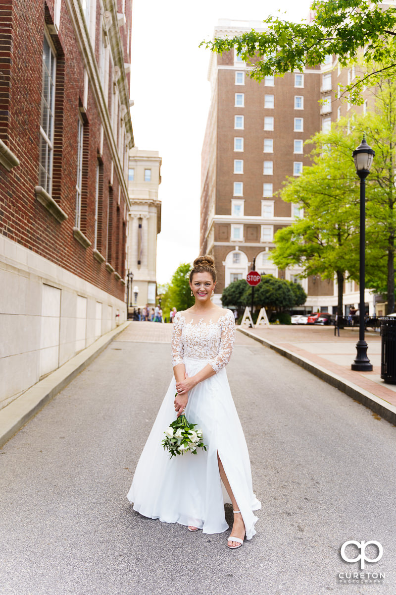 Bride holding her flowers walking down Main Street in downtown Greenville,SC.