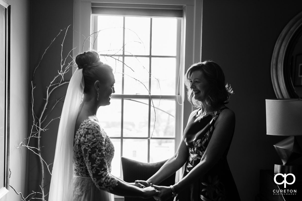 Bride's mother smiling at her as they share a moment before the ceremony at Soby's Loft.