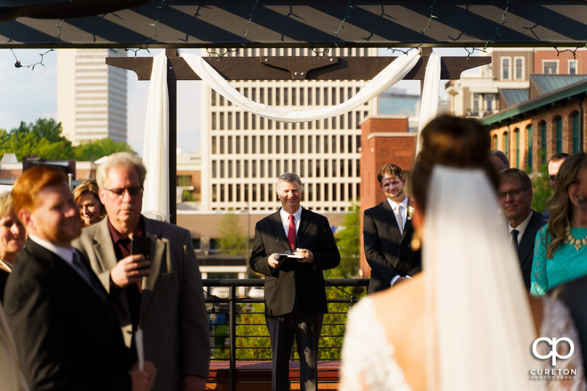 Groom seeing his bride for the first time as she walks down the aisle at their Loft at Soby's wedding in downtown Greenville,SC.