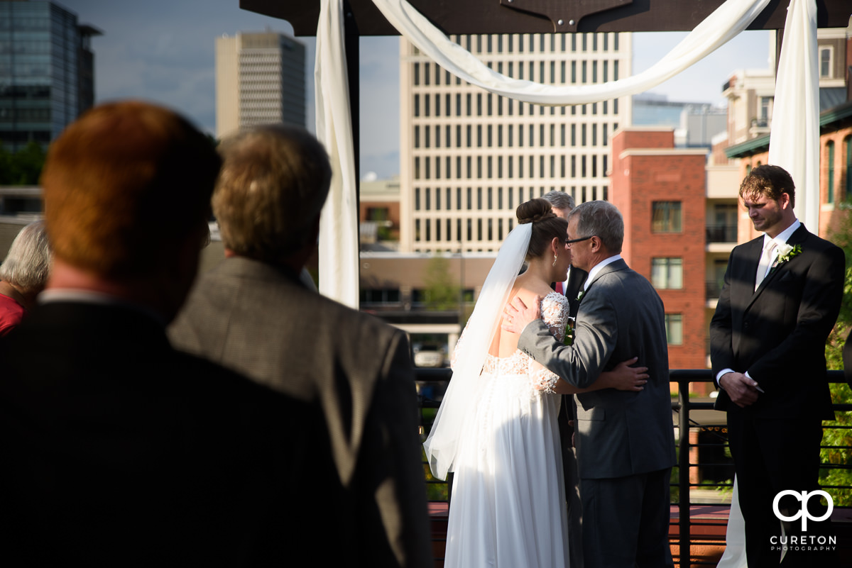 Bride's father giving her away at the ceremony.