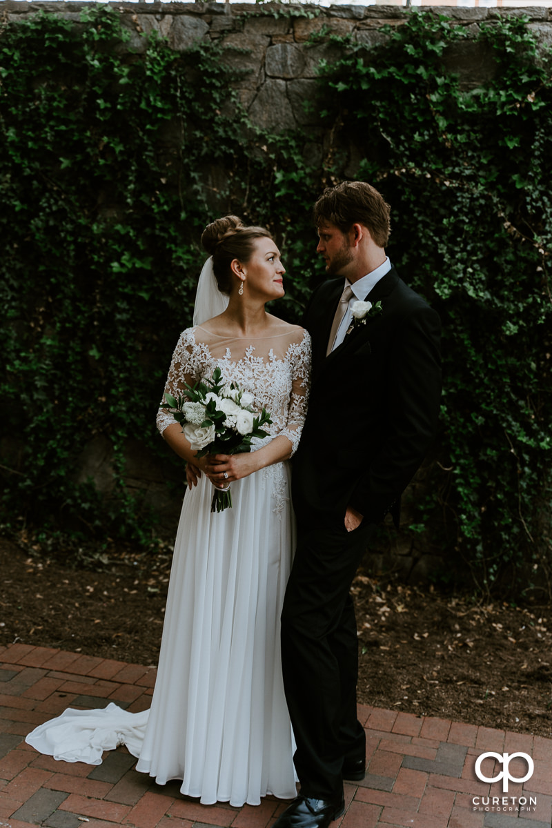 Bride and groom in front of a wall of ivy after their Loft at Soby's wedding in downtown Greenville,SC.